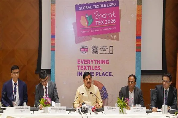 Bharat Tex 2026 बैनर के नीचे मेज पर मुख्यमंत्री और उद्योग प्रतिनिधि माइक पर